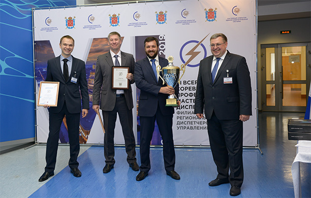 Заместитель главного диспетчера СО ЕЭС по оперативной работе Александр Курлюк (справа) награждает победителей – команду Кубанского РДУ